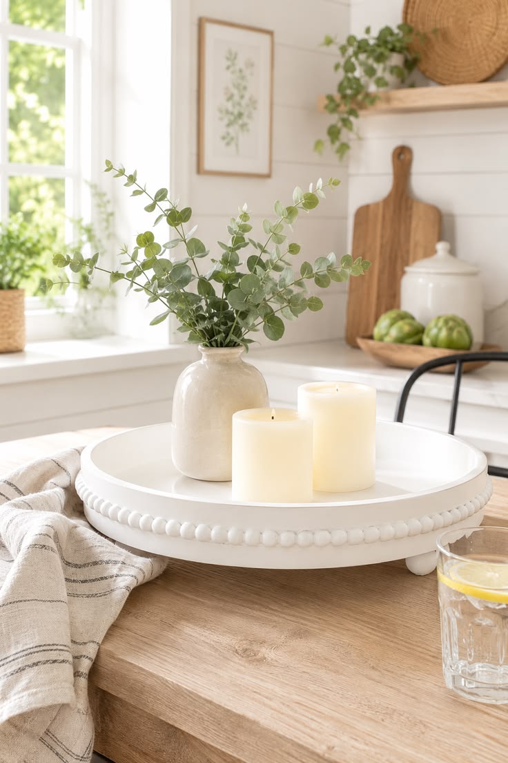 White decorative tray with vase and candles on table